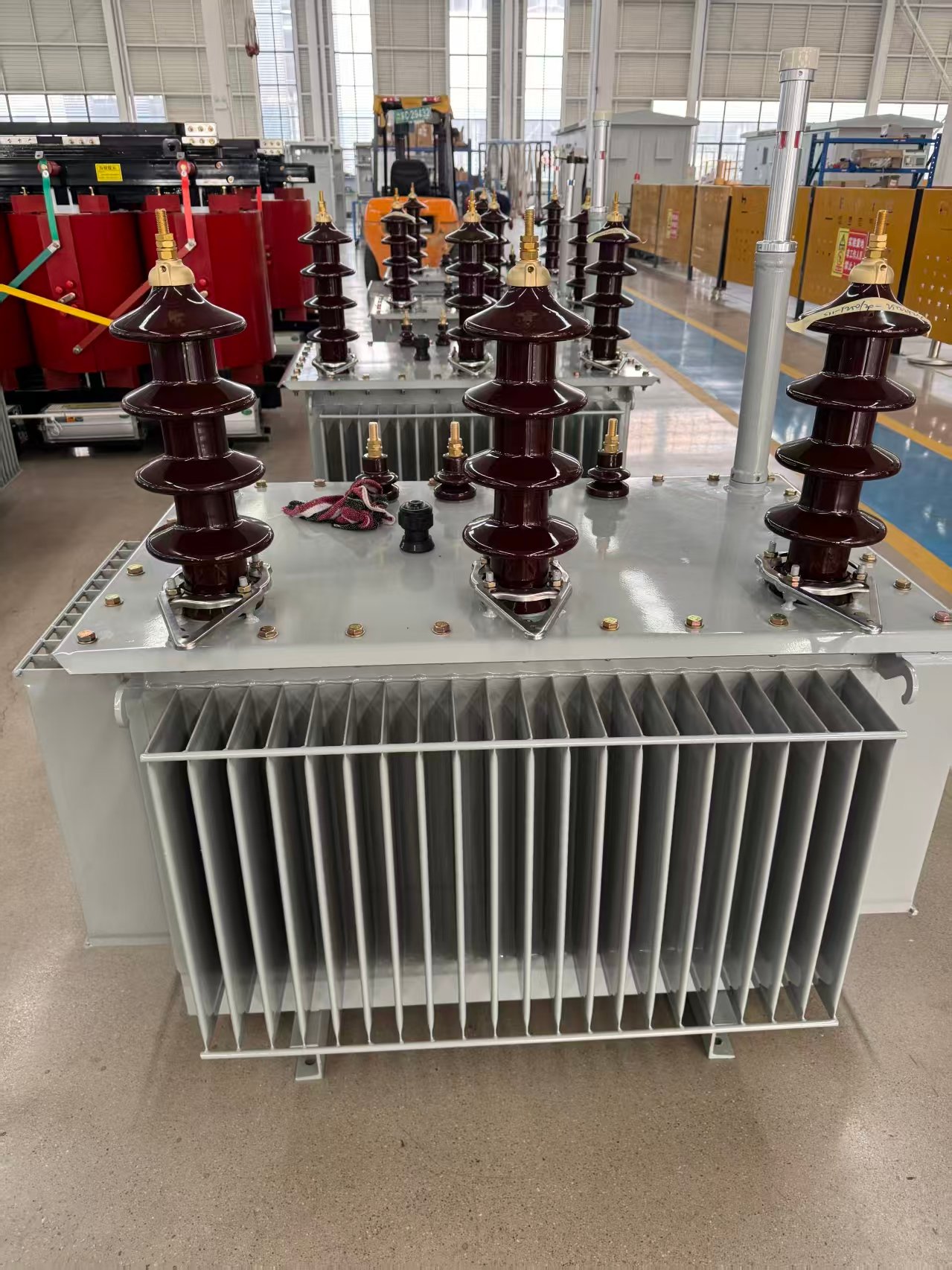 Oil transformer with bushings and cooling fins
